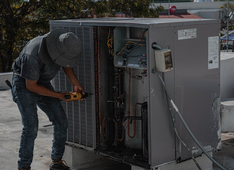 HVAC technician performing maintenance on outdoor unit